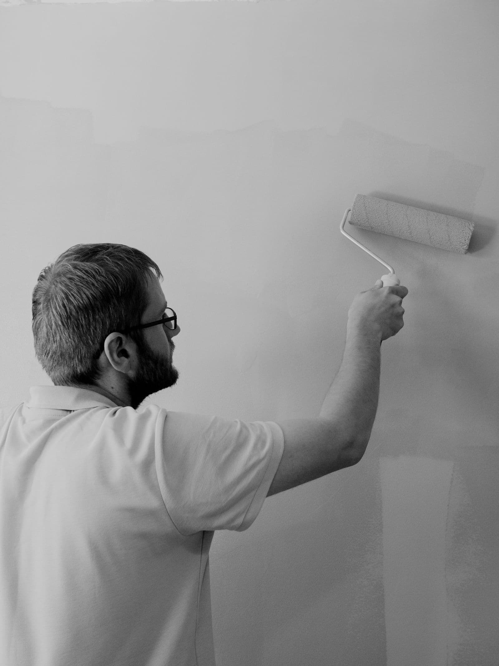 A painter rolling fresh paint onto an interior wall